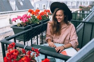 Happy woman at table with Laptop Computer